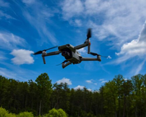 Agrolab_Drone_imaging_stock_photo Drone flying next to a forest and above a grassfield.